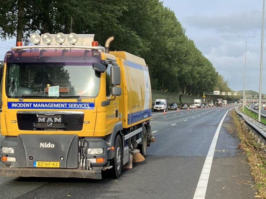 Het wegdek wordt schoongemaakt op de plek waar het ongeval gebeurde.