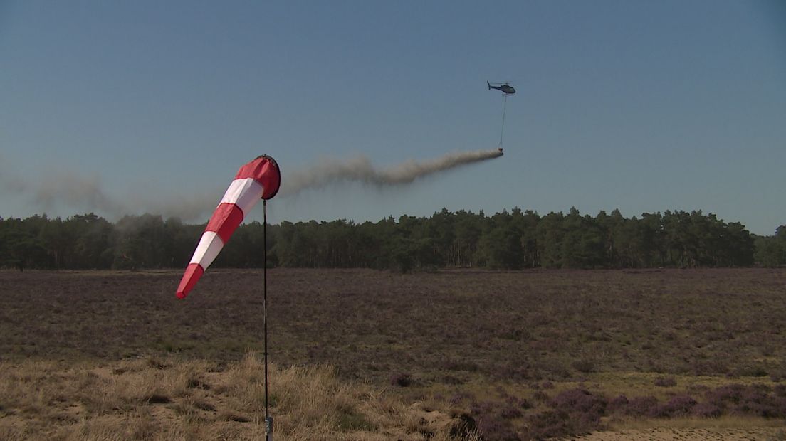 Een helikopter loost steenmeel.