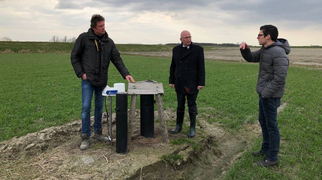 Gedeputeerde Staghouwer (midden) laat zich onder anderen door boer Hans de Boer bijpraten over de gevolgen van de rietproef