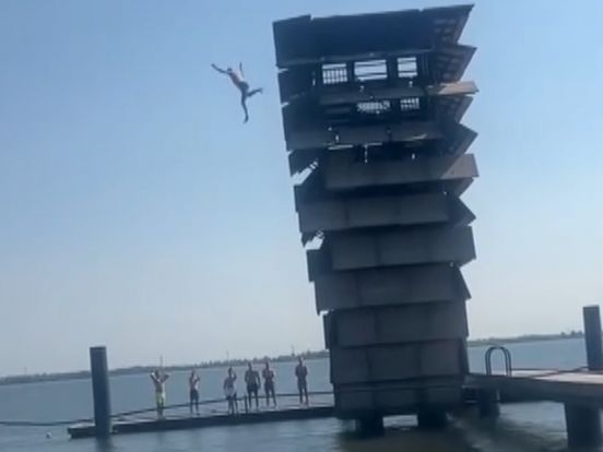 Een jongere springt van de tien meter hoge toren.