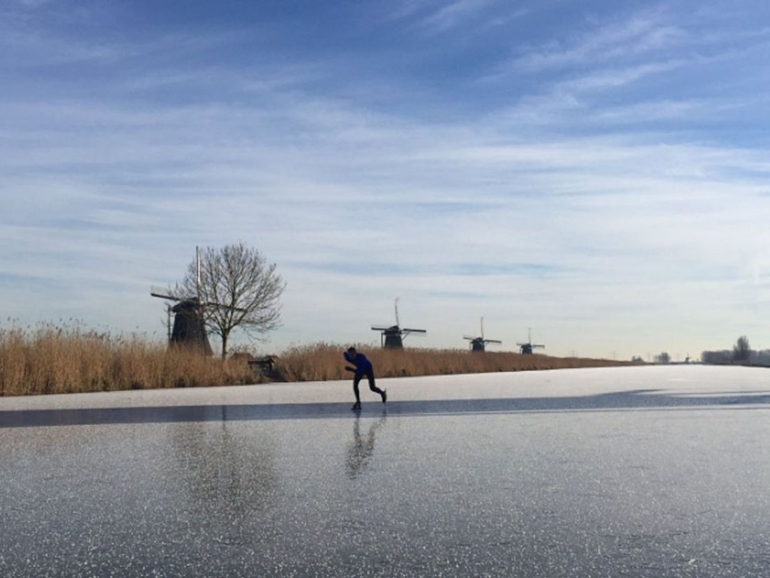 Er wordt geschaatst bij de molens van Kinderdijk.