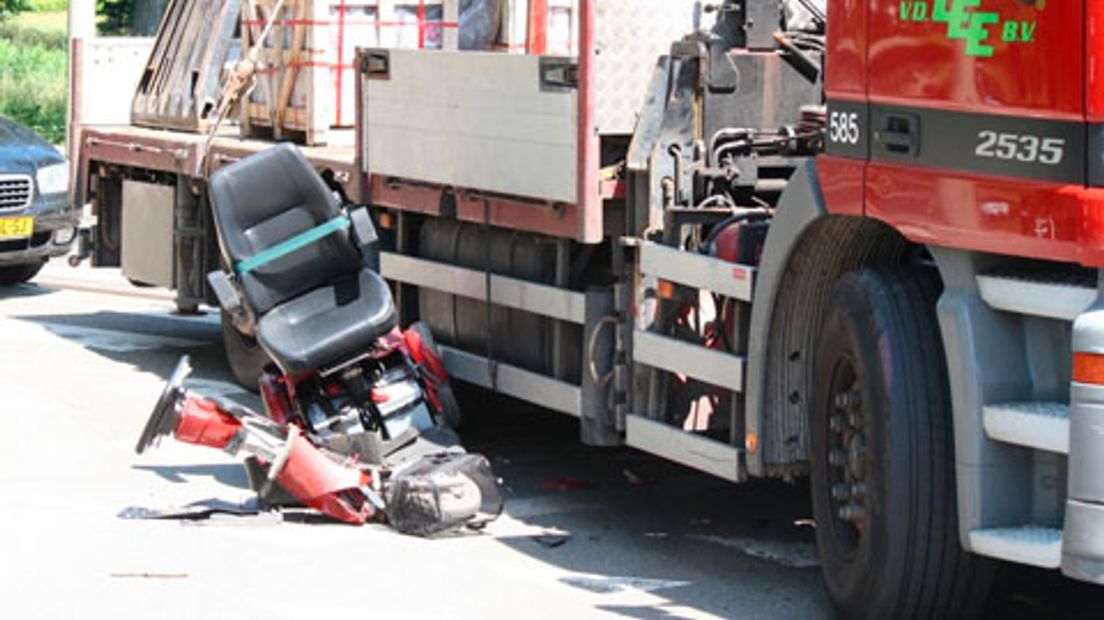 Scootmobiel onder vrachtwagen