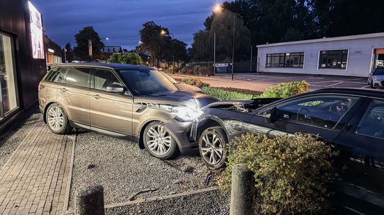 Automobilist botst op geparkeerde auto bij autohandelaar