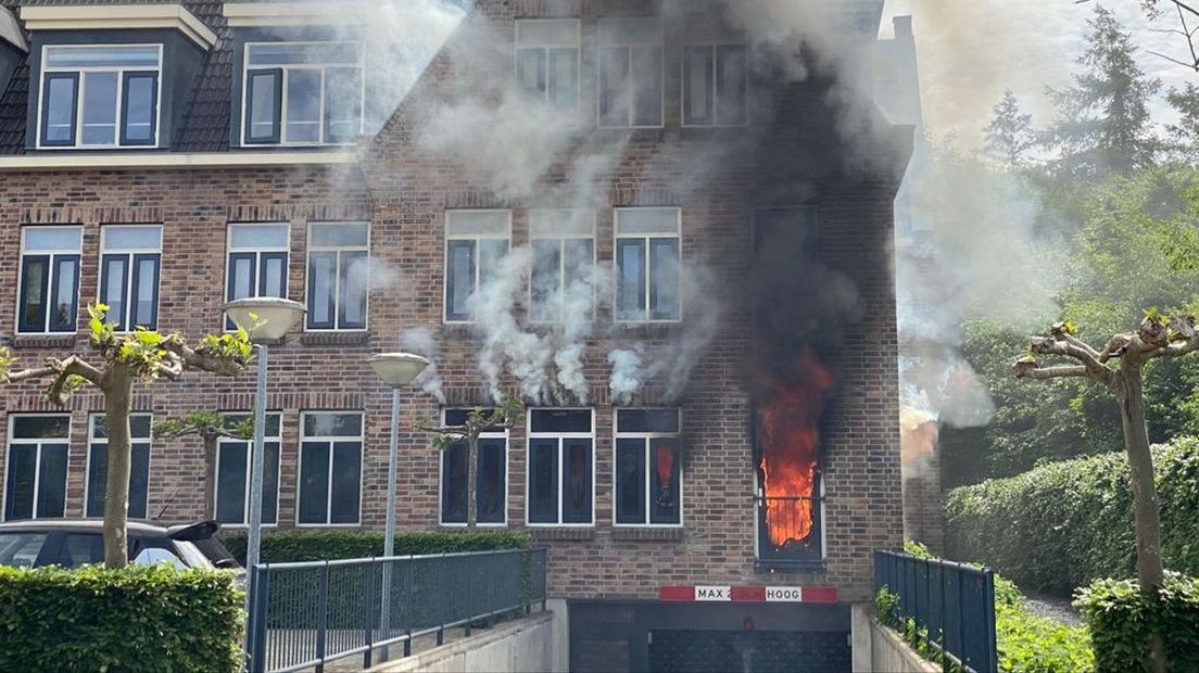 De vlammen slaan uit de woning.