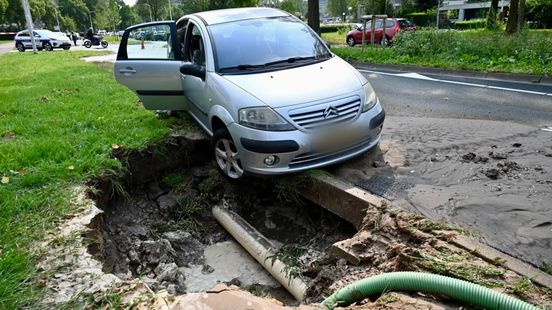 Veel ongelukken op de weg, auto bungelt boven sinkhole. Veel ongelukken op de weg, auto bungelt boven sinkhole.