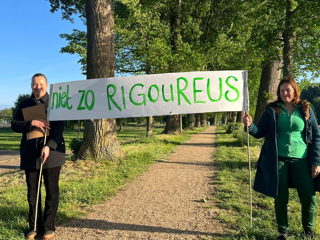 Omwonenden protesteren met een spandoek tegen de kap van 31 bomen in het Wollefoppenpark