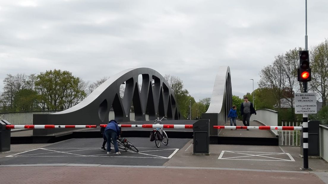 Fietsers kruipen onder de gesloten slagbomen door