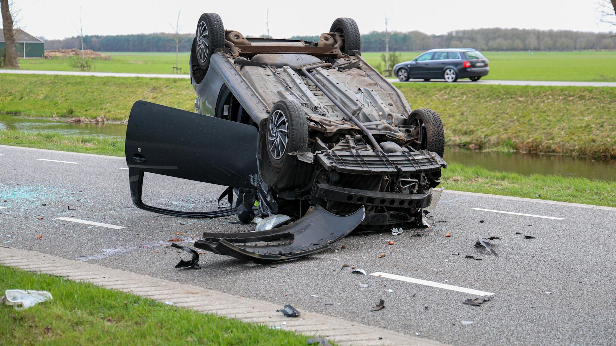 Auto op de kop na botsing met boom in Hoogersmilde