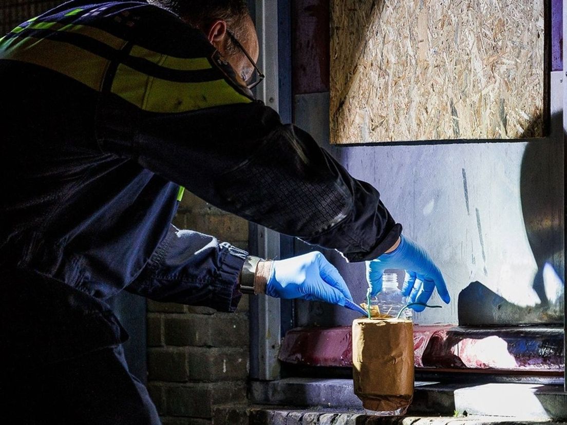 Een explosievenverkenner onderzoekt het verdachte pakket voor het appartementengebouw aan de Van Speykstraat