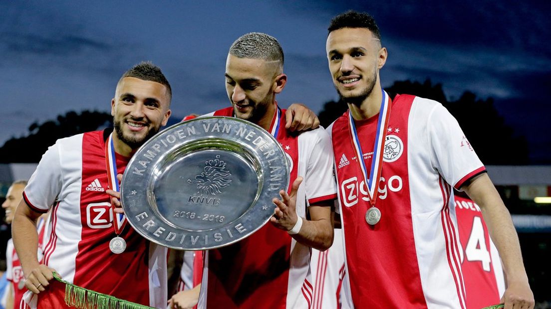 Noussair Mazraoui (r) viert de landstitel van Ajax met Hakim Ziyech (m) en Zakaria Labyad.