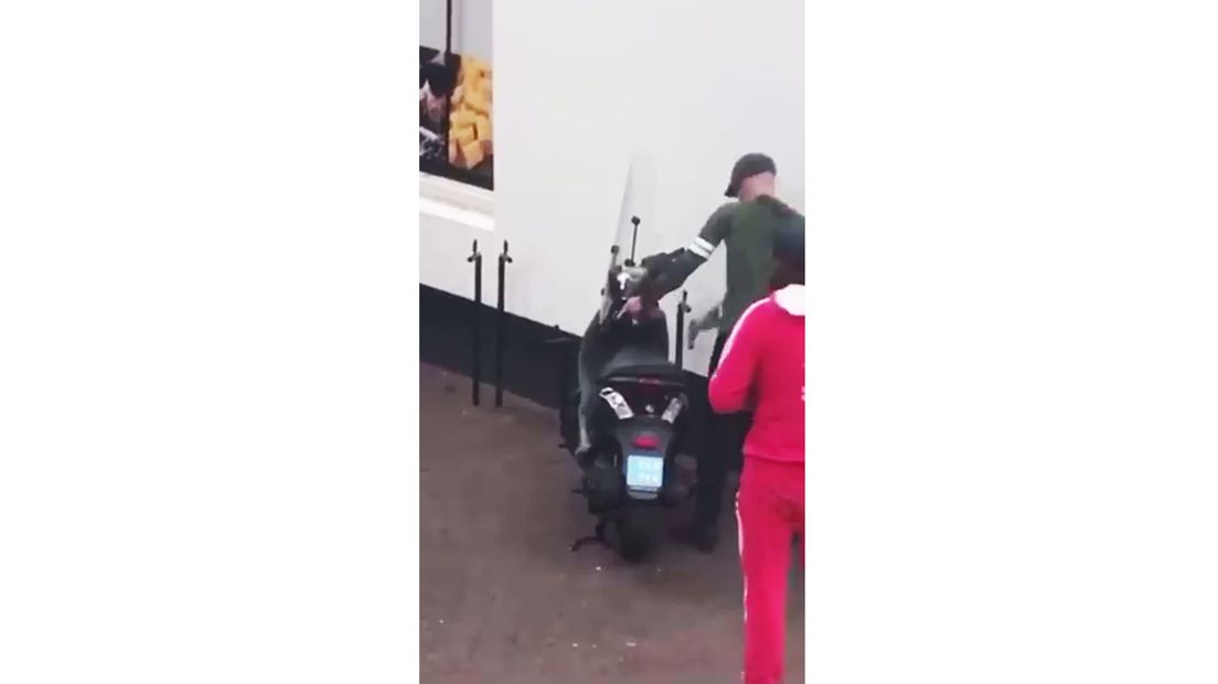 Eén man gebruikt een hamer terwijl de ander op de uitkijk staat