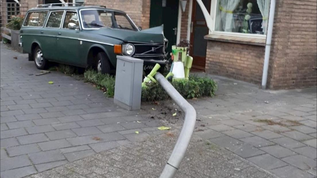 Automobilist ramt lantaarnpaal en woning