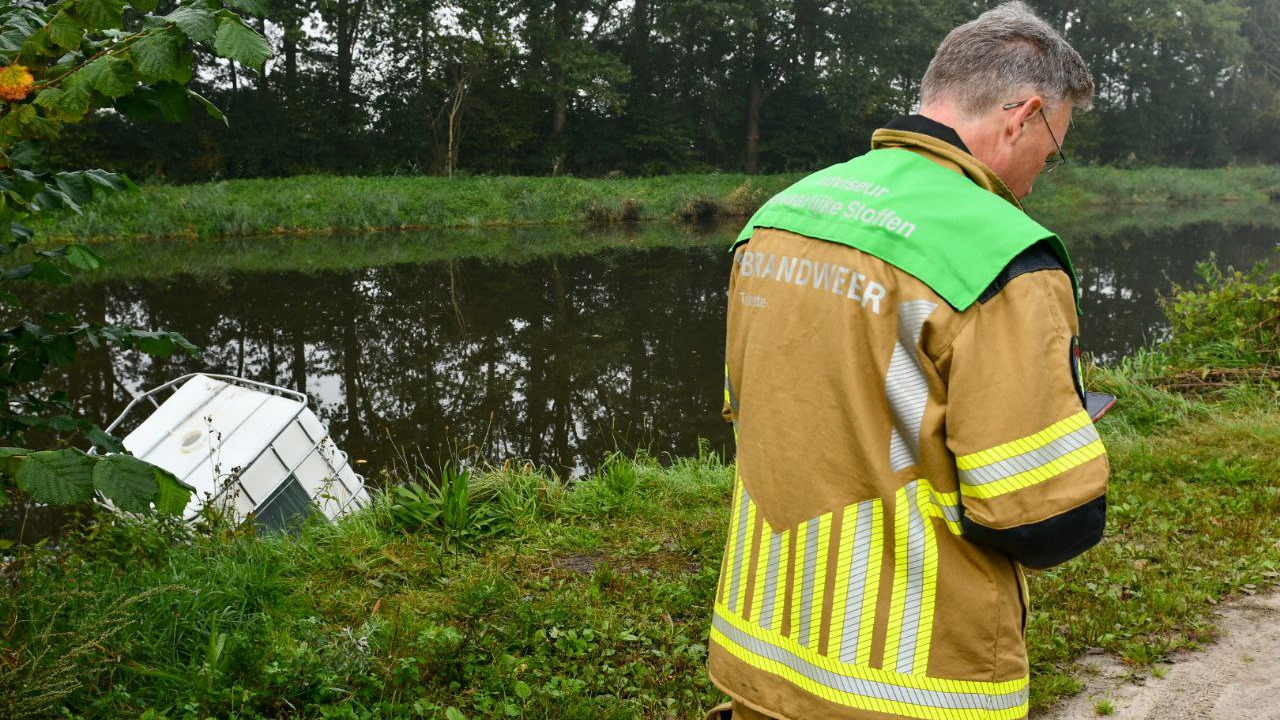 De brandweer neemt poolshoogte bij de gedumpte container in het kanaal