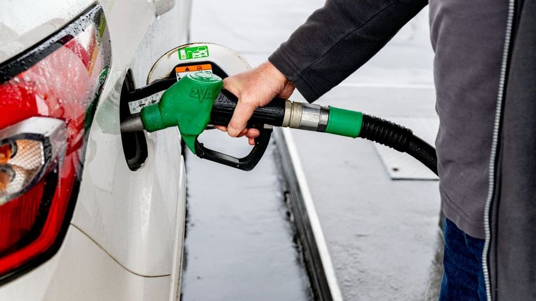 Een automobilist vult zijn auto met benzine bij een tankstation