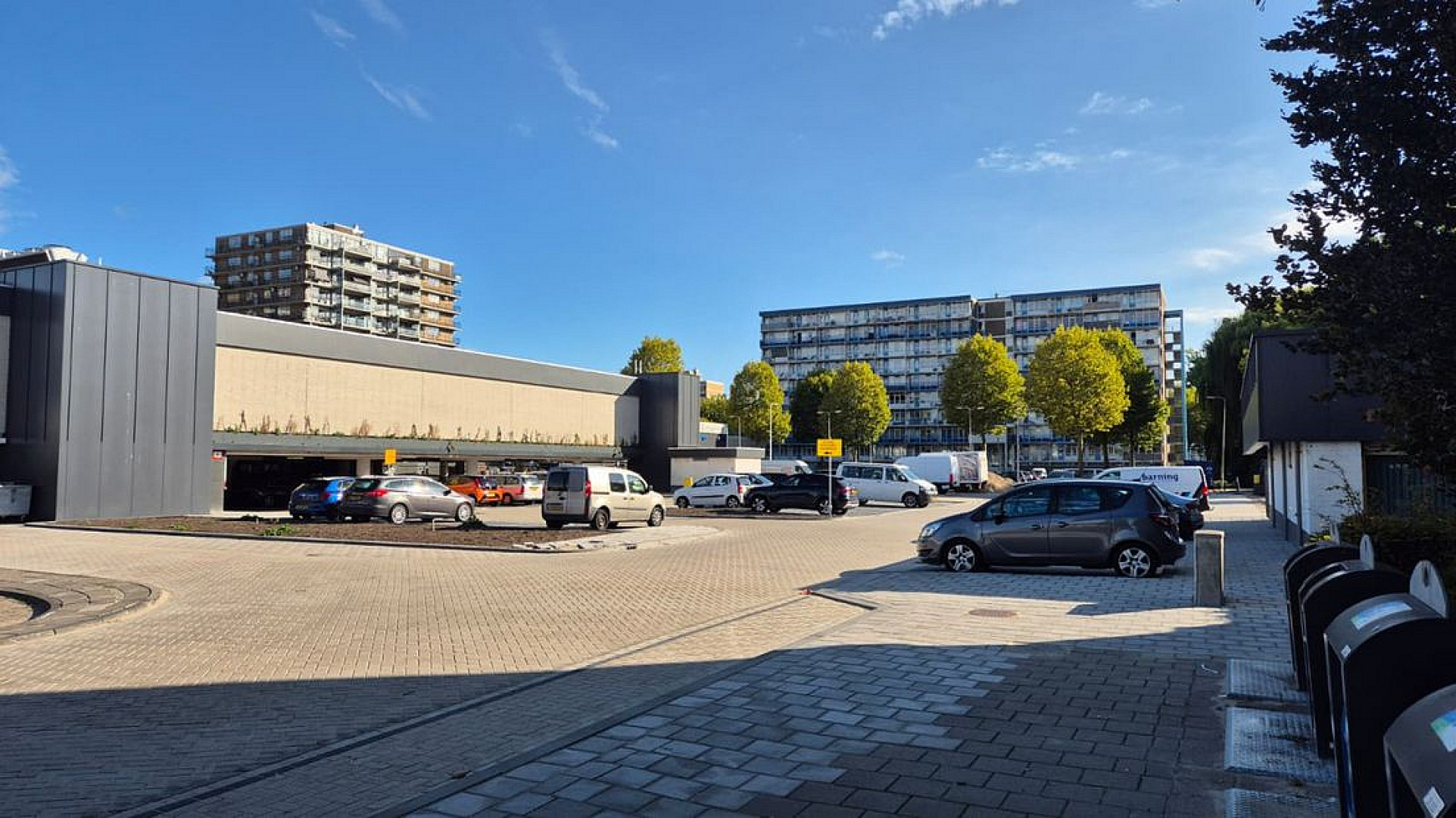 Op dit tijdelijke parkeerterrein, pal naast het winkelcentrum, moet de nieuwe flat komen