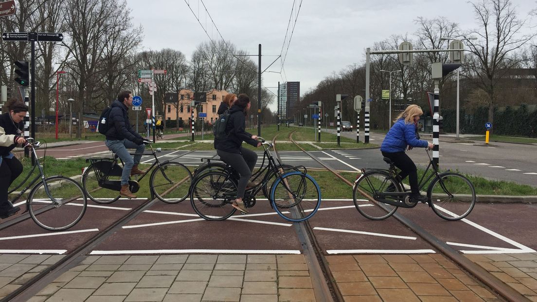 Fietsers kruisen de Uithoflijn.