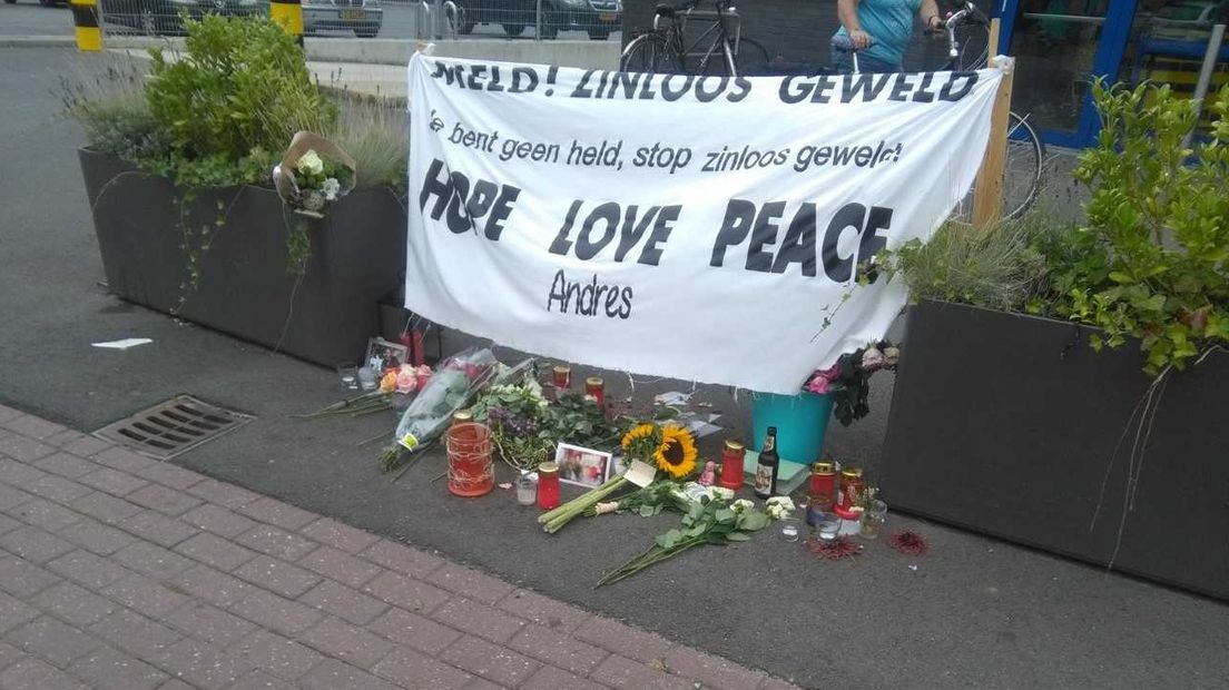 Een spandoek, bloemen en kaarsjes liggen tussen de bloembakken bij de Lidl in Warnsveld. Hier werd begin juli Andres Rodriguez mishandeld. Hij overleed een paar dagen geleden.