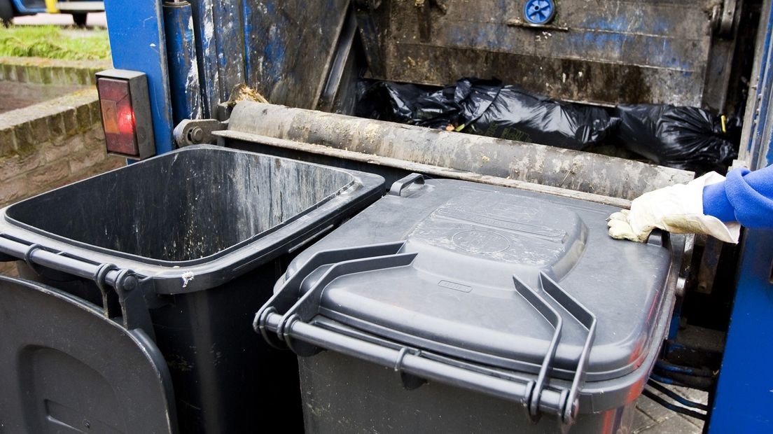 Containers worden geleegd in een vuilniswagen