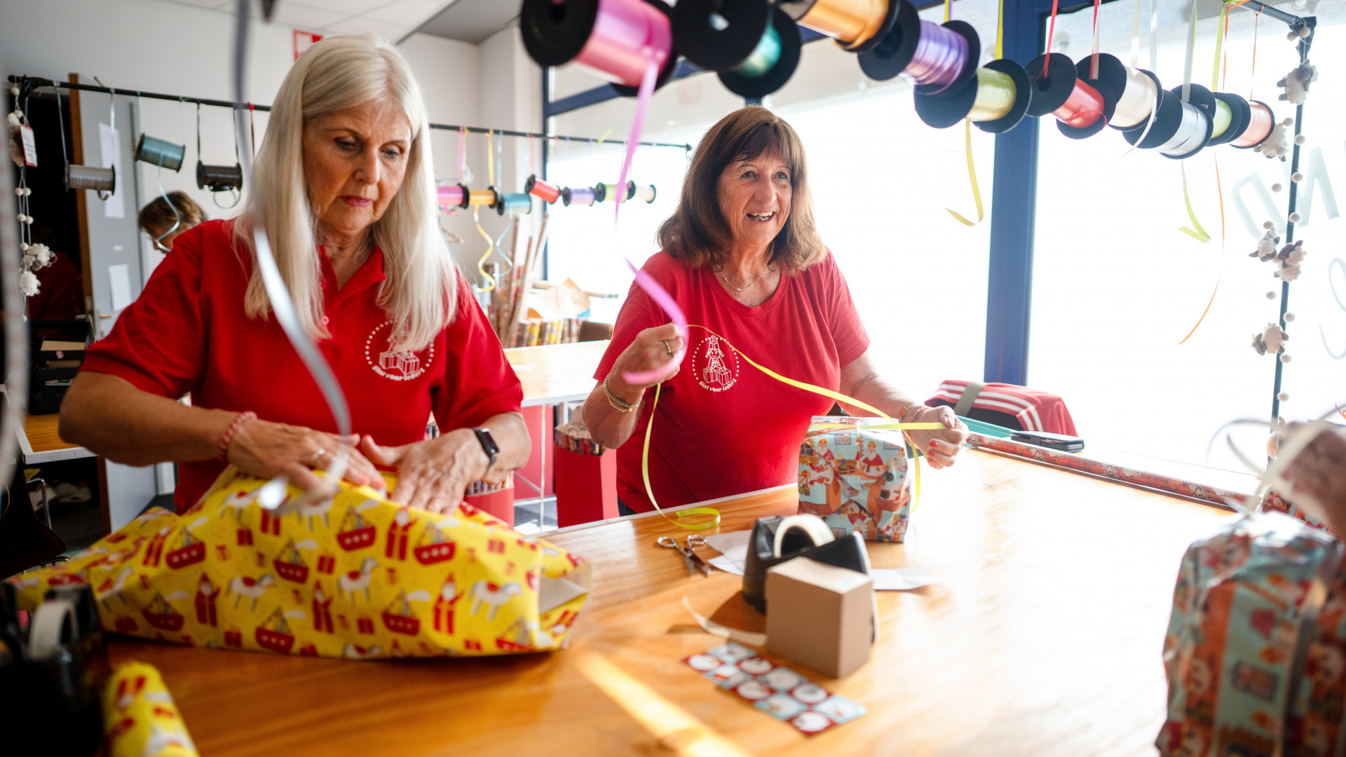 Vrijwilligers pakken cadeaus in