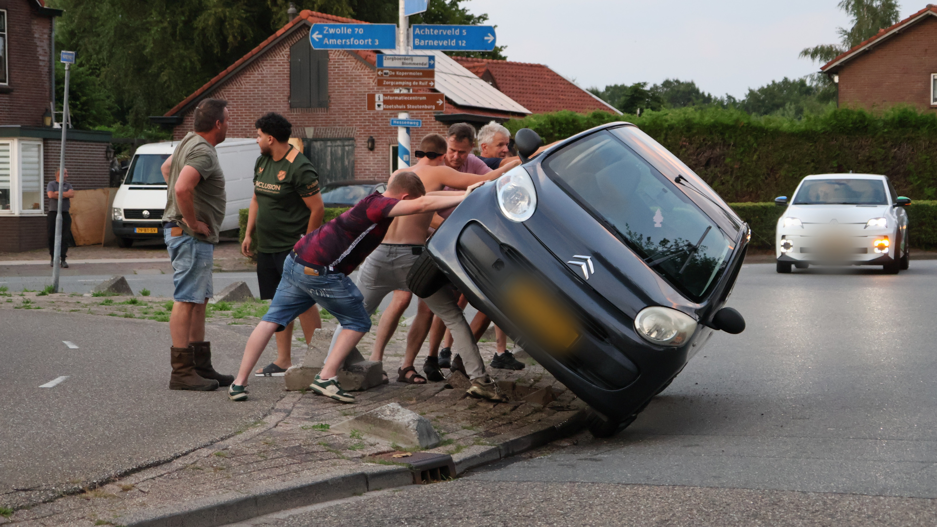 Automobilist rijdt zich vast op betonblok, bewoners schieten te hulp