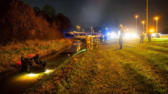 Foto: Auto in sloot naast A73 • achteras auto breekt