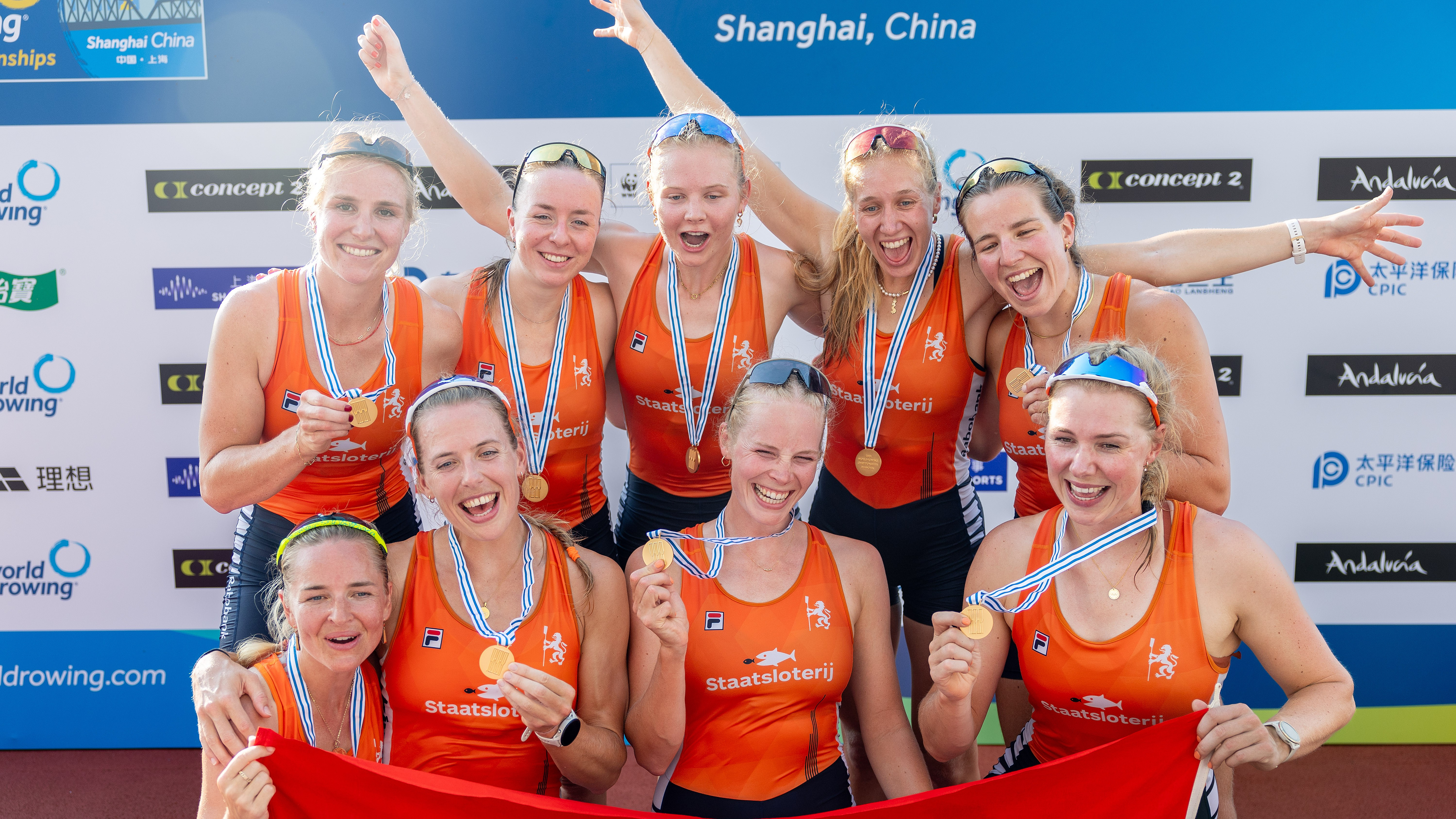 De Vrouwen-acht met hun gouden medaille met Ilse Kolkman, zittend tweede van rechts.