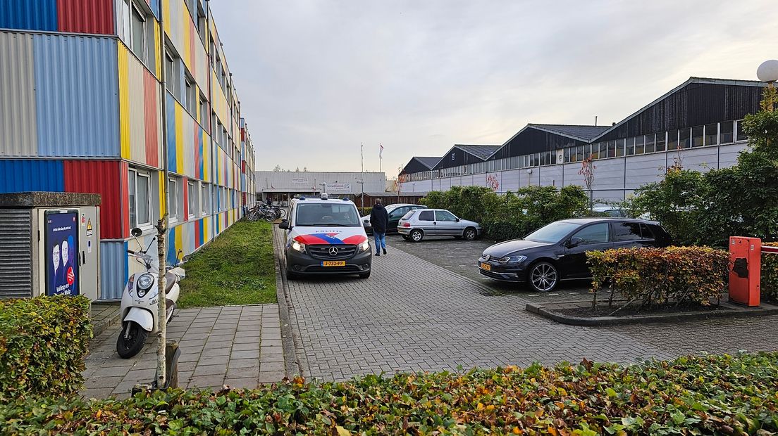 Politie bij de gekleurde wooncontainers en de kringloopwinkel aan het Damsterdiep