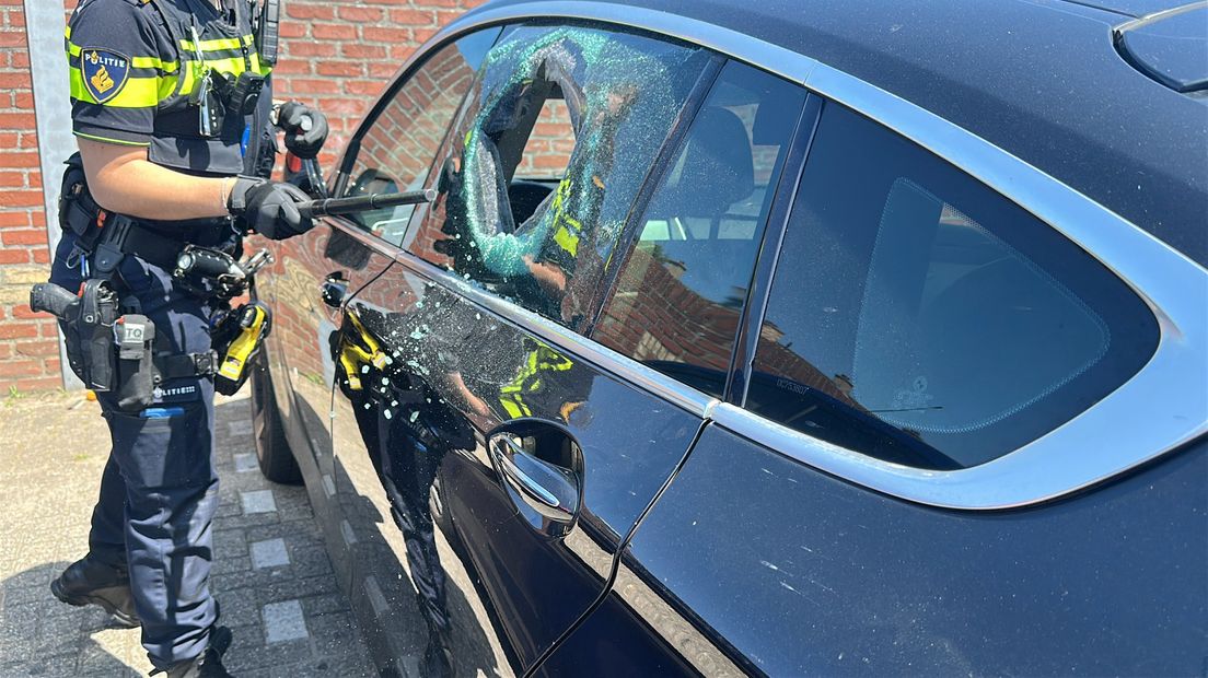 Een agente tikte een zijraam van de auto in om de hond te redden