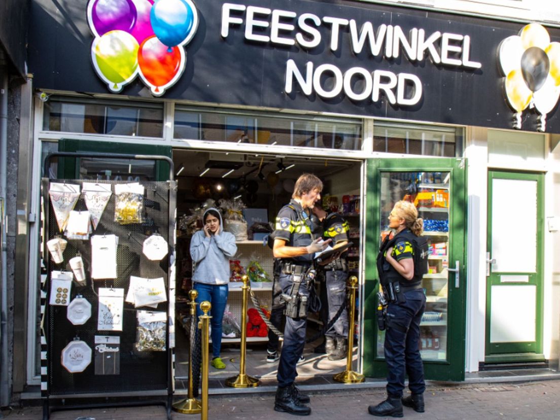 Politie voor de overvallen feestwinkel in Rotterdam-Noord