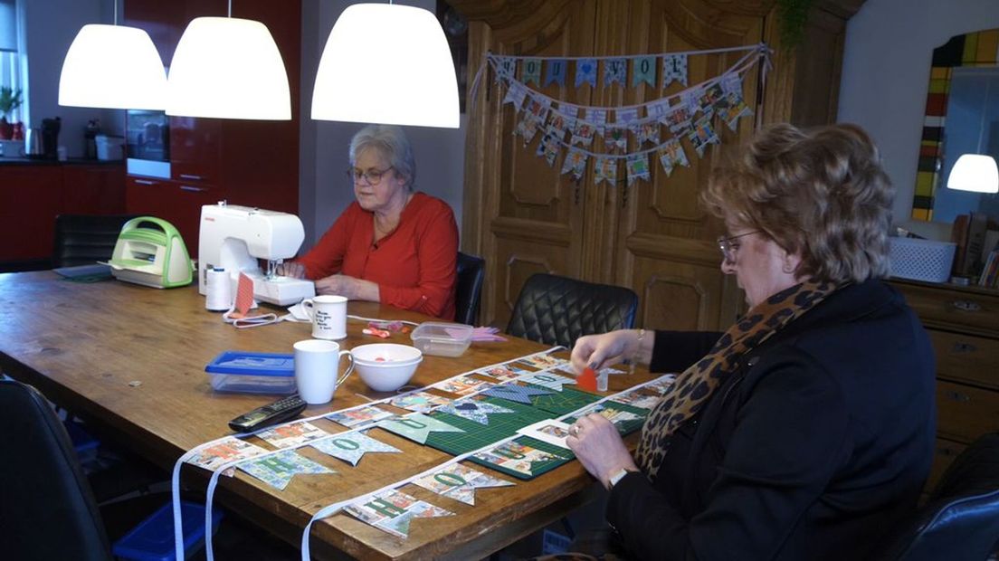 Irma en Brigitta maken slingers.