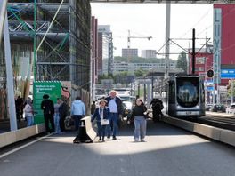 Reizigers hebben de tram verlaten en gaan te voet verder over de Erasmusbrug.