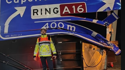 Een medewerker van Rijkswaterstaat met het beschadigde bord