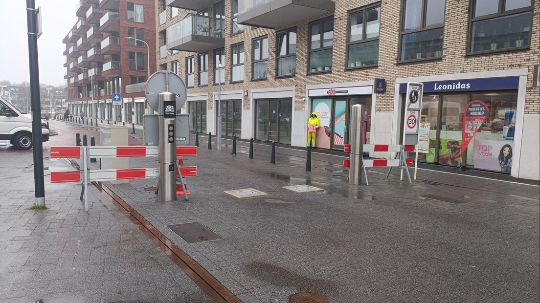 Een naargeestige situatie bij het HagaZiekenhuis: twee werkloze palen en een verregende verkeersregelaar