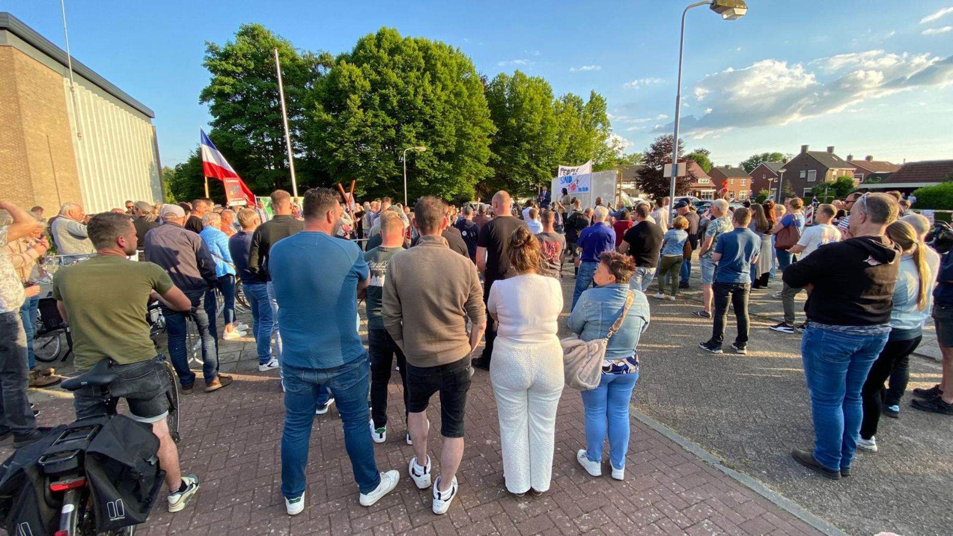 Demonstranten tegen de plannen voor een azc in Aalten op de parkeerplaats bij de Zuiderkerk