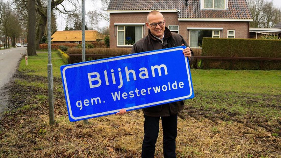 Bart Huizing laat het aangepaste plaatsnaambord van Blijham zien, met de nieuwe gemeentenaam.