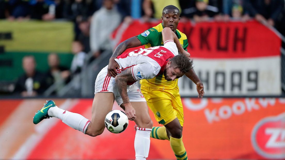 ADO-speler Gervane Kastaneer in duel met Ajax-speler Mitchell Dijks