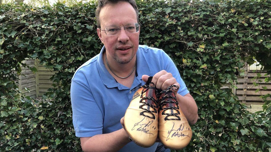 De schoenen van Arjen Robben in handen van Sjoerd-Jan Gispen (Supportersvereniging FC Groningen).