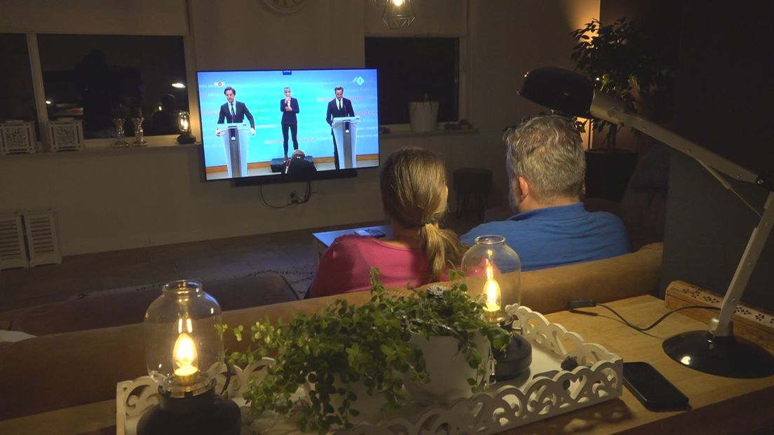 Rijschoolhouder Jan van Veen en zijn vrouw Siska kijken naar de persconferentie over de versoepeling van de coronamaatregelen