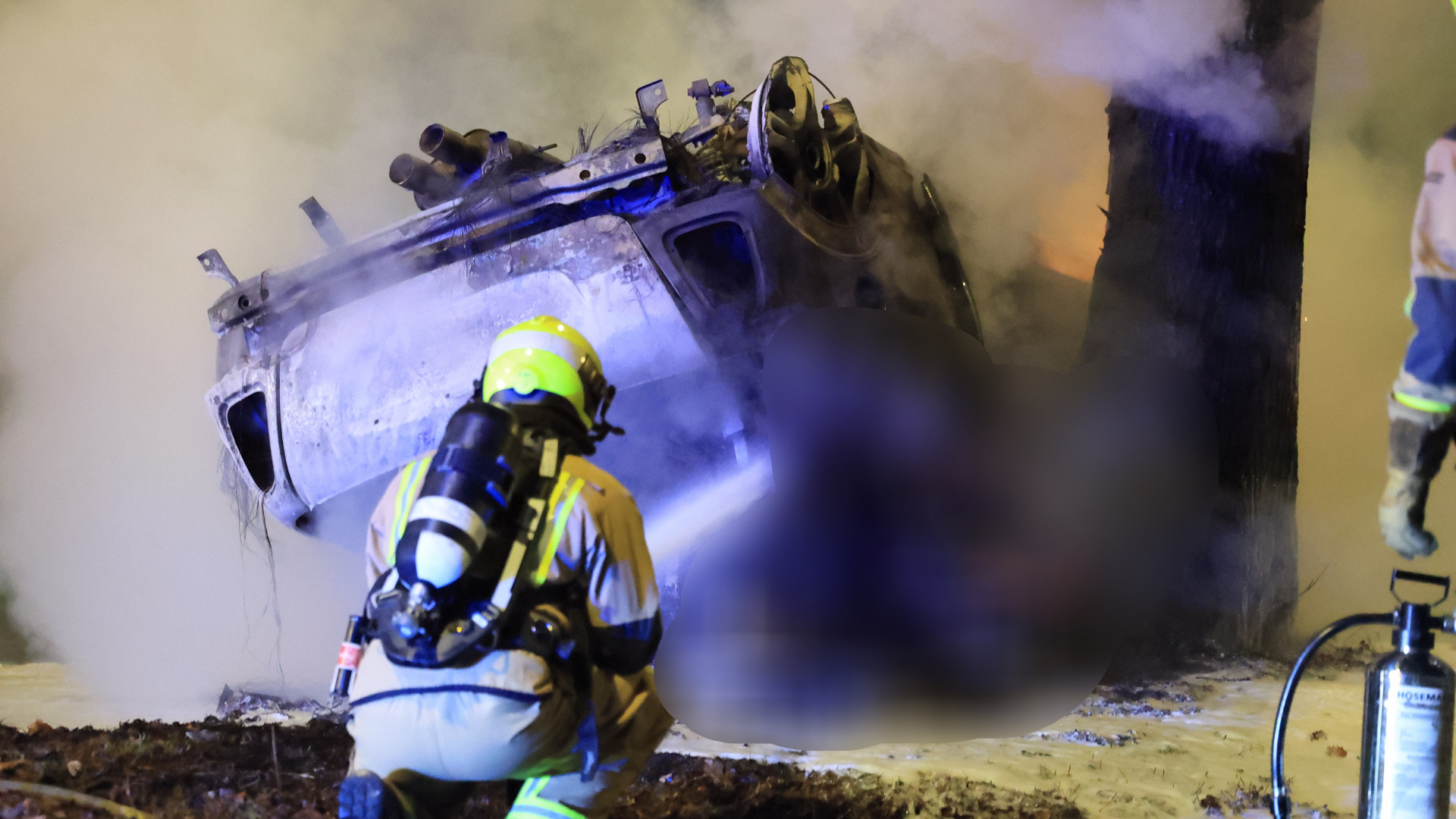 De uitgebrande auto ligt ondersteboven na de crash