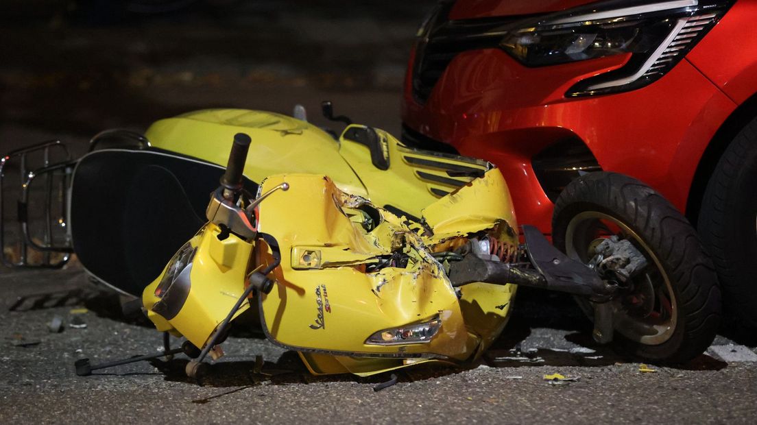 De scooter kwam voor een geparkeerde rode auto terecht