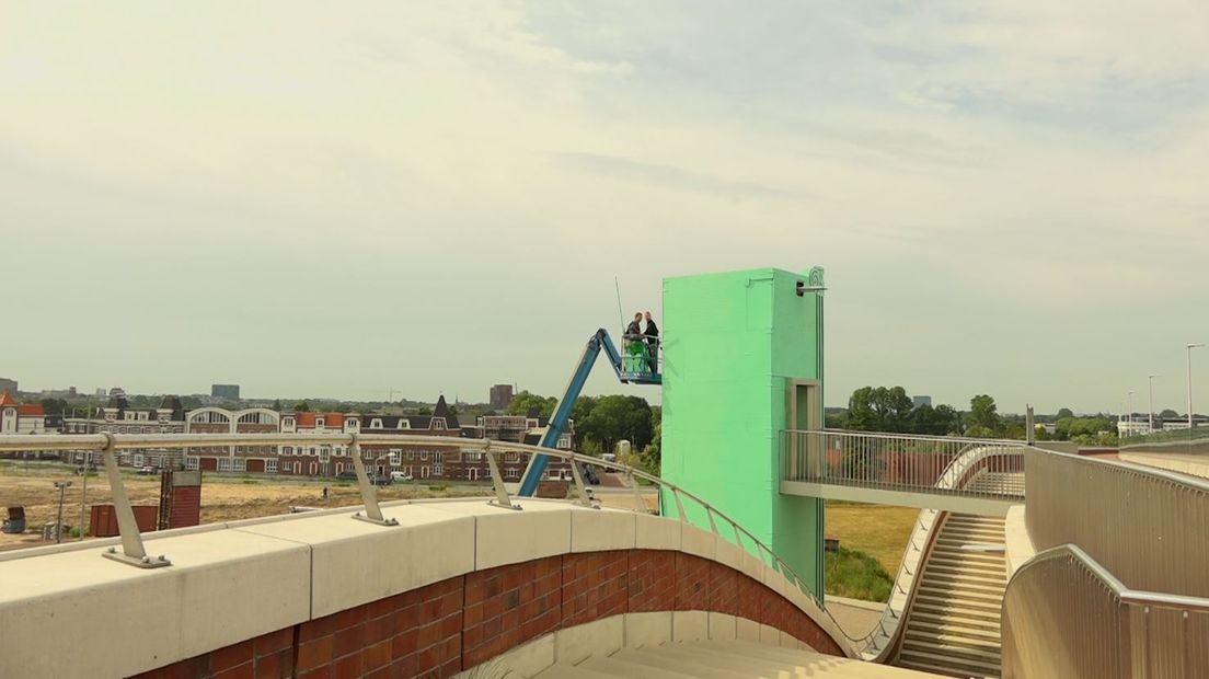 Een knalkleur is het. Mintgroenig. Kunstenaar Marcel Blom uit Nijmegen is druk in de weer met verf en dergelijke. Bijzonderheid aan zijn nieuwste creatie: Hij maakt kunst van een glazen lift in zijn woonplaats die bij herhaling doelwit was van vandalen.