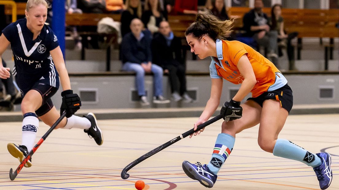 Florentine Blom, in het oranje shirt, breekt door de defensie van Pinoké heen