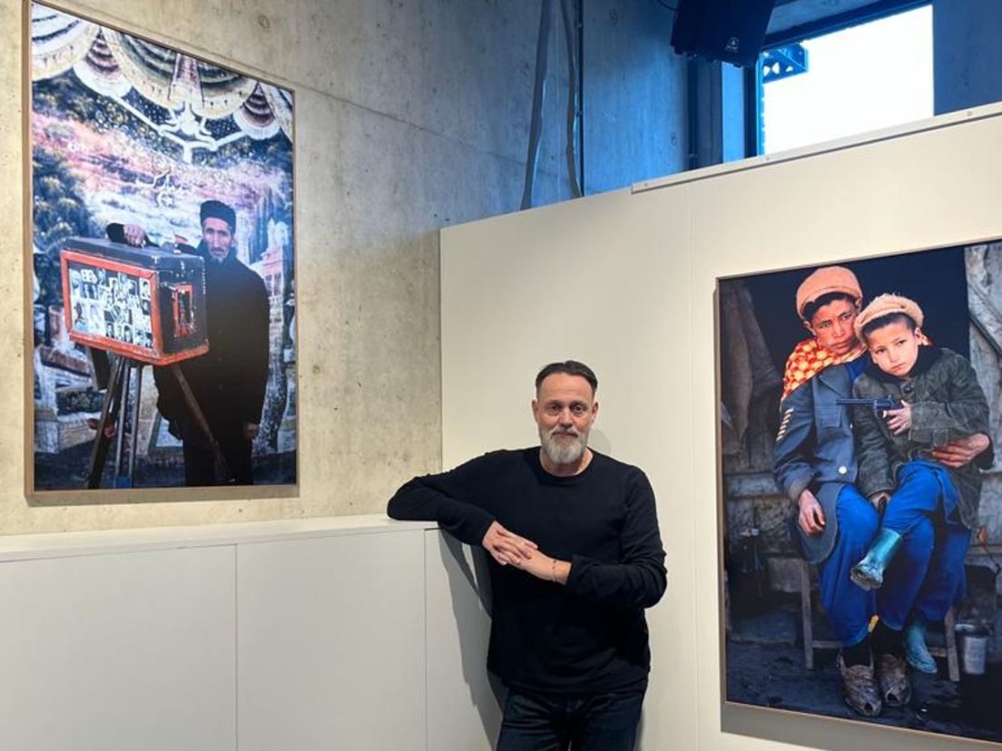 Atelierhouder Hugo Borst van galerie Weisbard voor twee foto's van Jan Henderik.