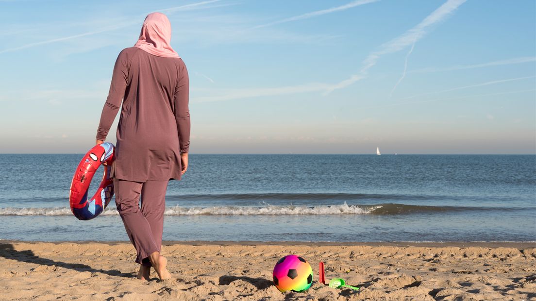 Vrouw in boerkini op het strand