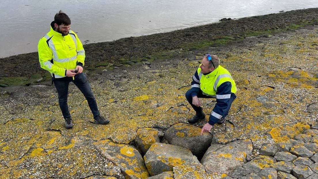 De inspecteurs bekijken de steenbekleding op de dijk