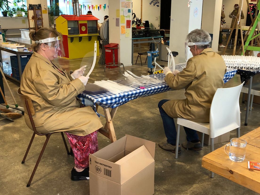 Vrijwilligers zetten maskers in elkaar in de Speelfabriek