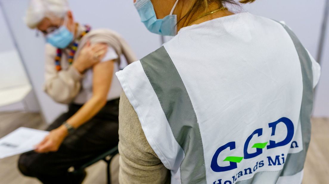 Een medewerker van de GGD Hollands Midden zet een coronavaccinatie