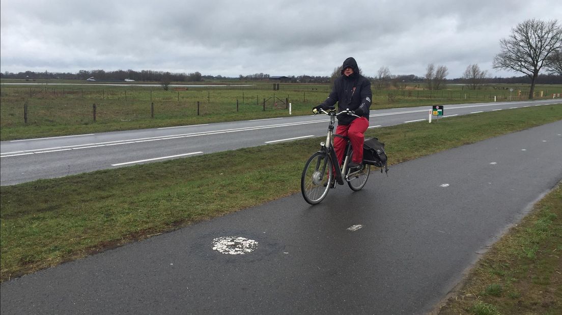 De eenzame fietser trotseert windvlagen in het IJssellandschap