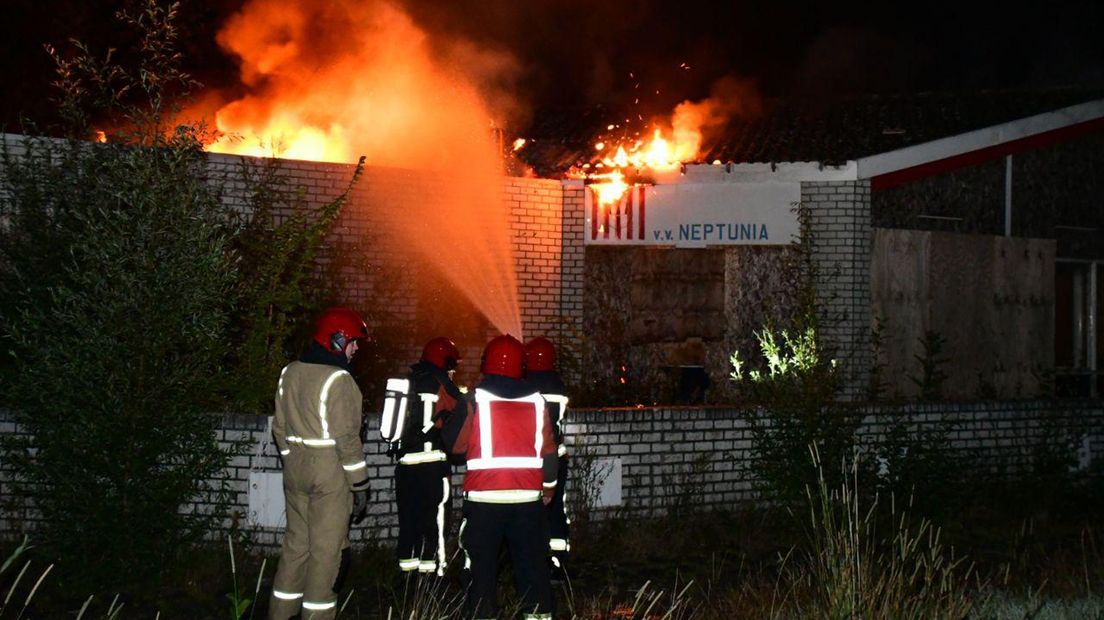 Brandweerlieden bestrijden het vuur bi het oude clubgebouw van VV Neptunia