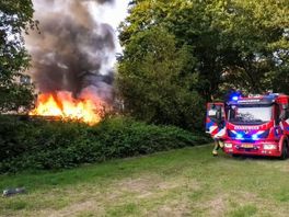 Vlammen slaan uit bijgebouw achter woning aan de Bentelobrink in Enschede